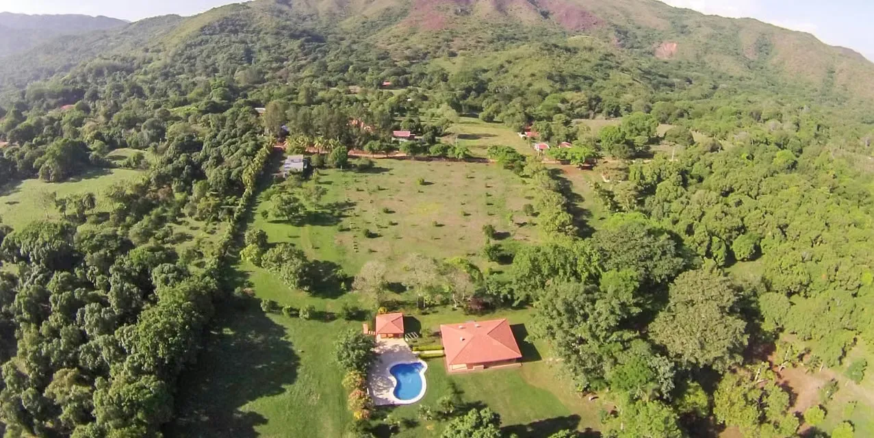 Tropical fruit farm with main and guest houses, pool, and BBQ rancho in San Pablo de Turrubares. 26 hectares with mango and avocado trees, paved access, and utilities. Costa Rica