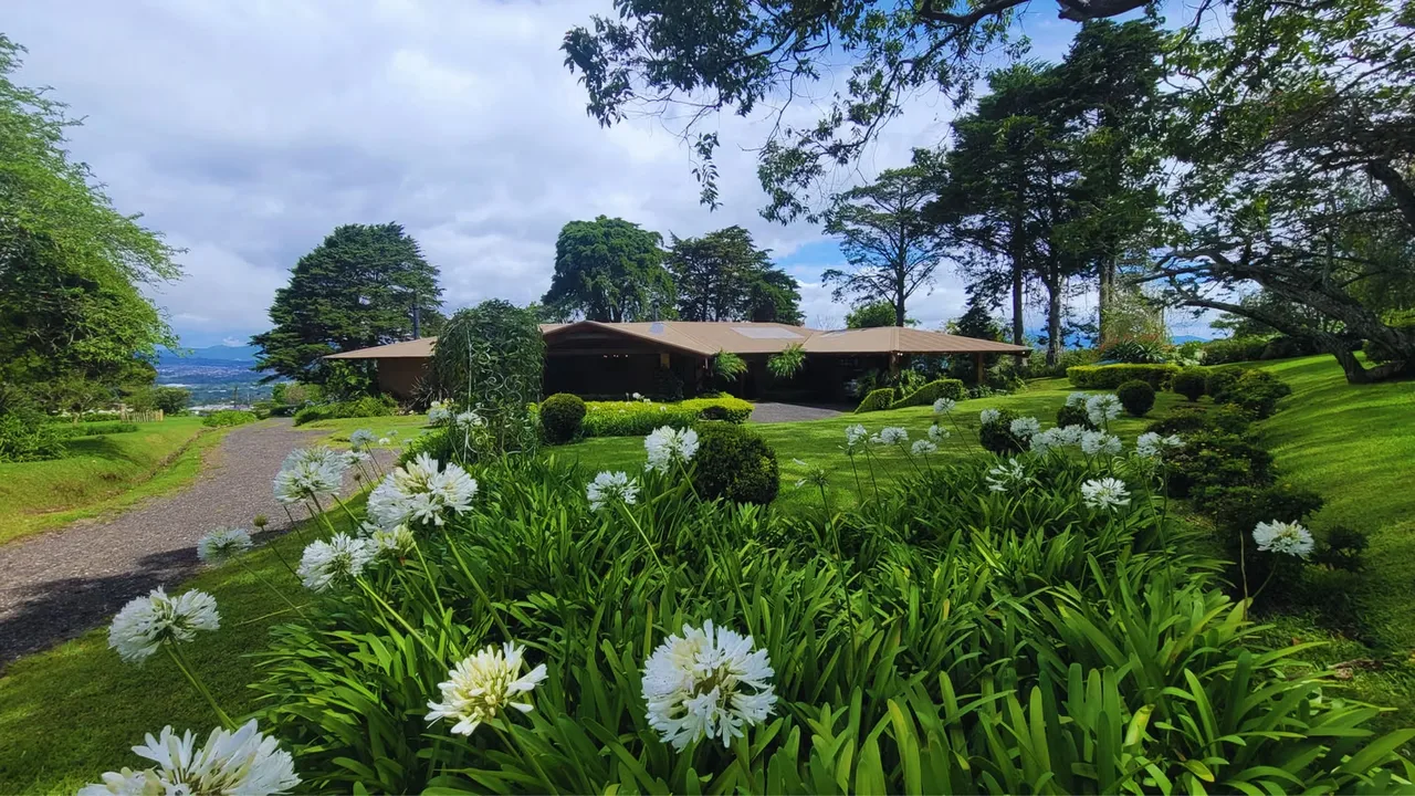 Villa privada de una sola planta ubicada en la zona alta de San Rafael de Heredia, con vistas panorámicas, amplios jardines y una arquitectura de carácter singular.