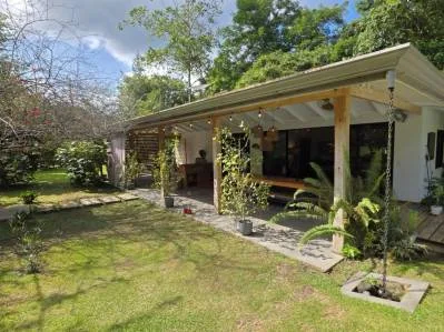 Finca tropical de estilo bohemio-chic con casitas y vistas a la montaña.